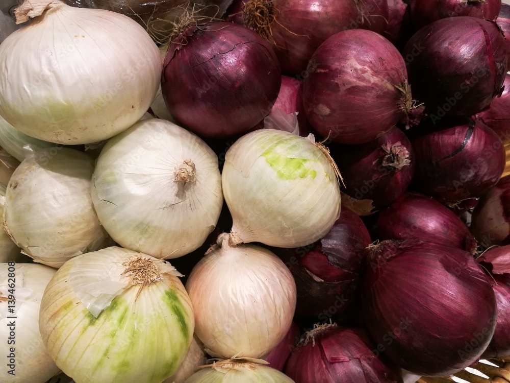 Fresh organic white onion bulbs and red shallot among many onion and shallot background in the basket in supermarket. Heap of onion root. Close-up red onion shallot texture Fresh organic white onion bulbs and red shallot among many onion and shallot background in the basket in supermarket. Heap of onion root. Close-up red onion shallot texture