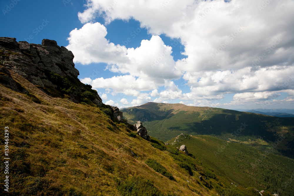 Carpathian mountains on blue sky and white clouds background.