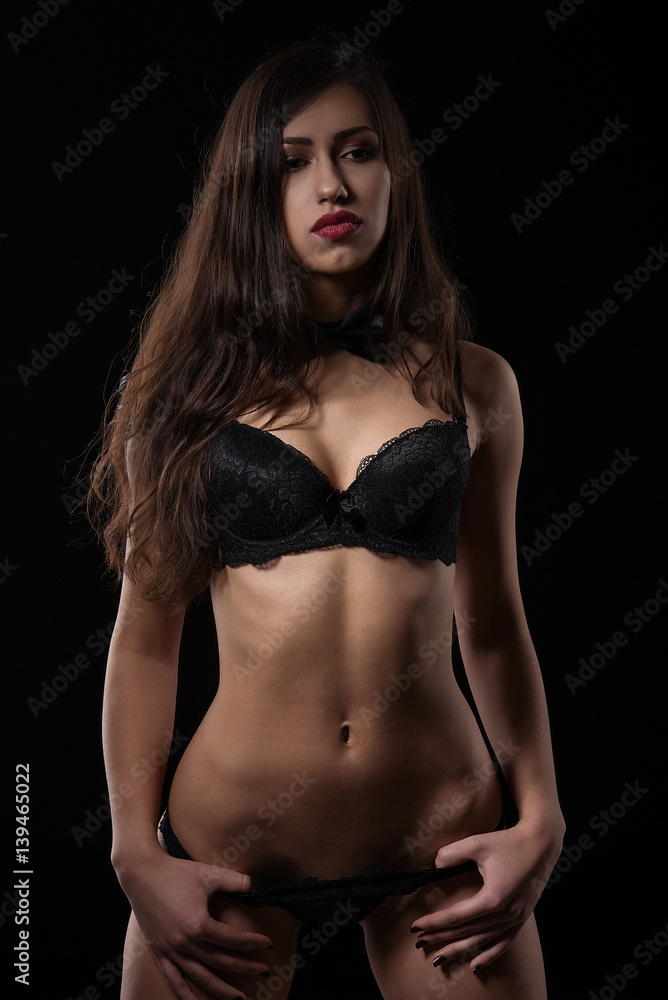 Seductive young woman posing in black sexy lingerie.