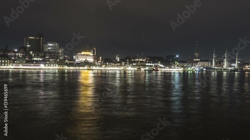 Panomic time lapse from the opposite riverside of the Elbe in Hamburg, on the skyline of hamburg, st. Pauli, Landungsbruecken, Baumwall, in evening time. Night Scene. 4k