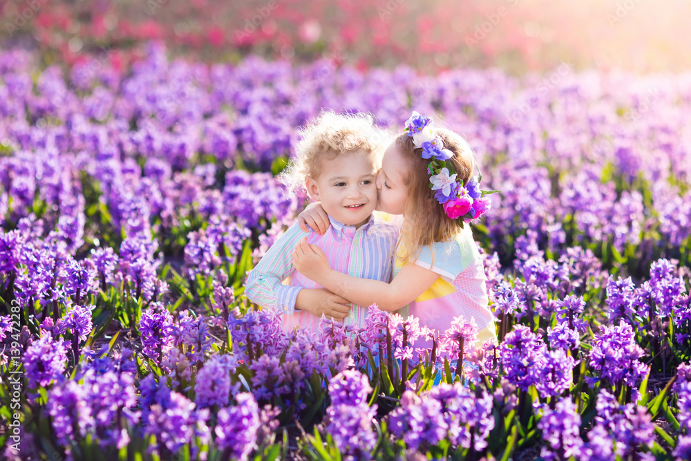 Kids playing in blooming garden with hyacinth flowers