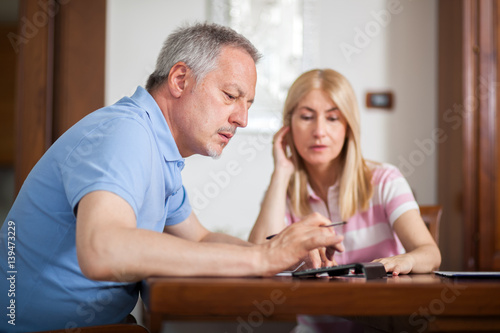 Senior couple working out their bills at home