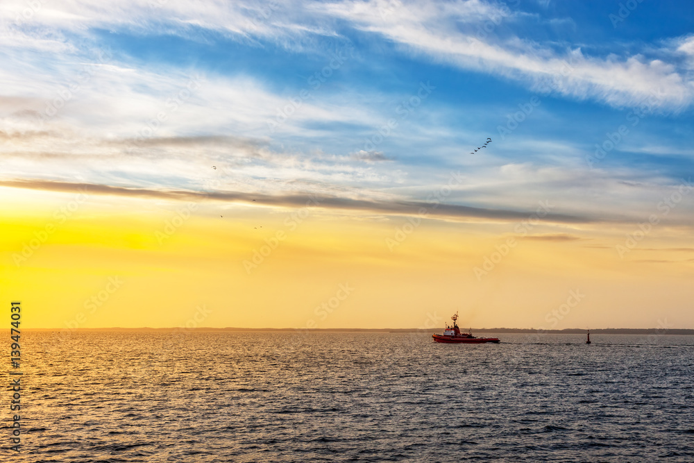 Tugboat at sunset on sea
