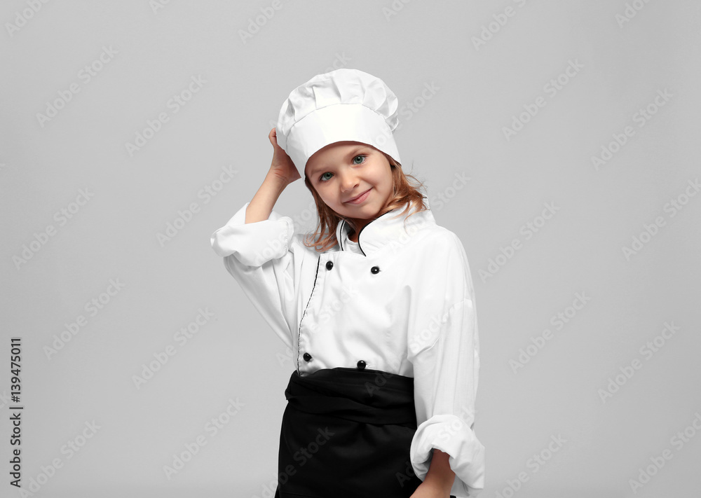 Cute girl in chef uniform on light background Cute girl in chef uniform on light background