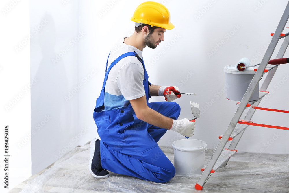 Young worker making repair in room Young worker making repair in room