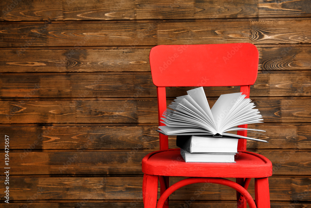 Fototapeta premium Chair with new books on wooden background