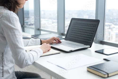 Canvastavla Office worker typing, working at her workplace, using laptop.