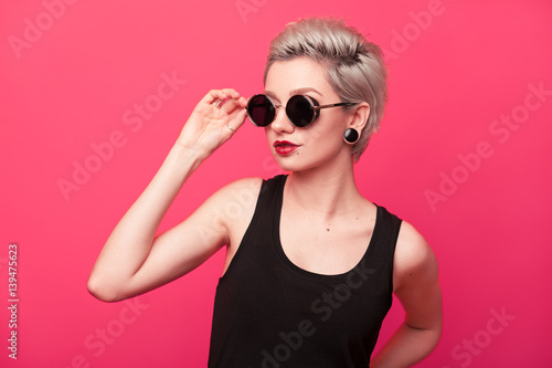 Stylish fashion portrait of young woman on pink background
