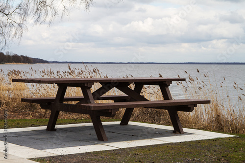 Hölzerne Sitzbank mit Tisch am Ufer eines Binnensee © Bernd Wolter