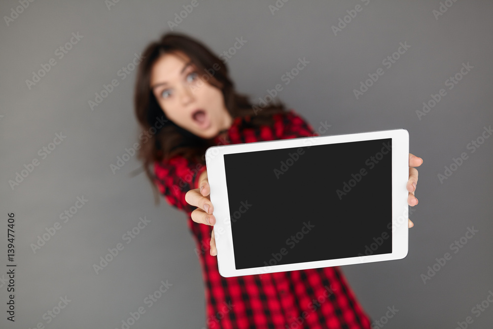 Closeup of shocked girl holding a blank screen tablet. Closeup of shocked girl holding a blank screen tablet.
