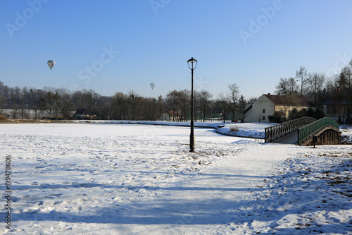 Piękny park zimą, most, latarnie i lot balonem.