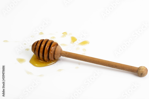 Freshly fragrant honey into a bowl and dipper on white backgroun