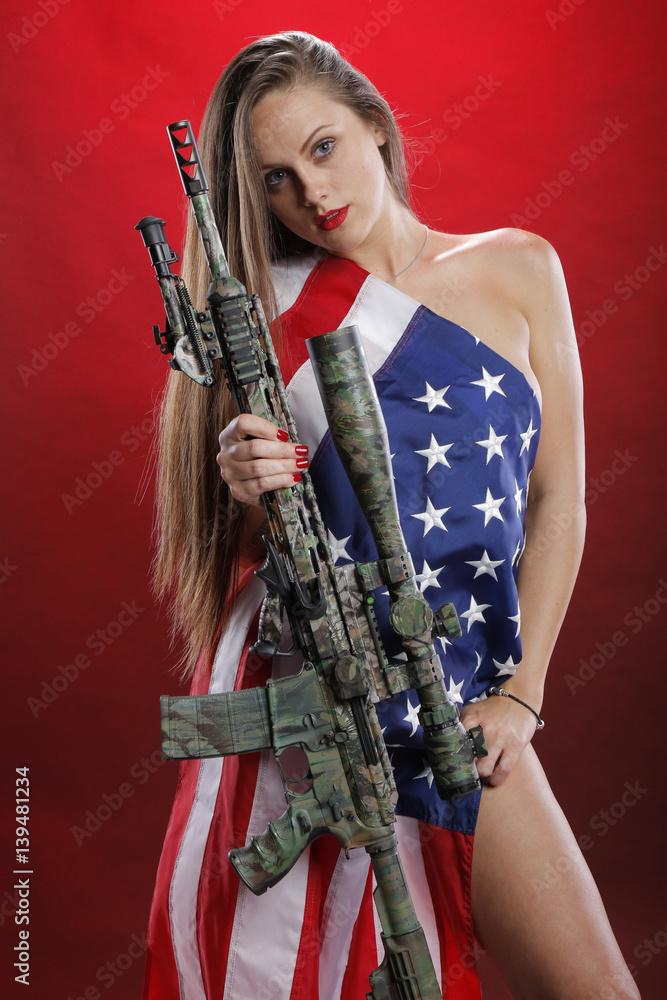 Woman carrying a sniper rifle and wearing an American flag Woman carrying a sniper rifle and wearing an American flag