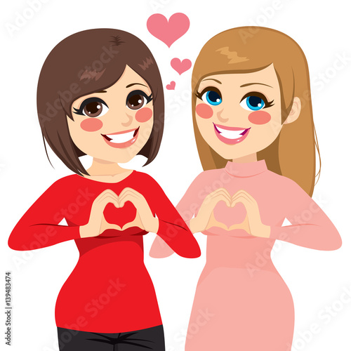 Two best friends girls smiling showing heart gesture with hands