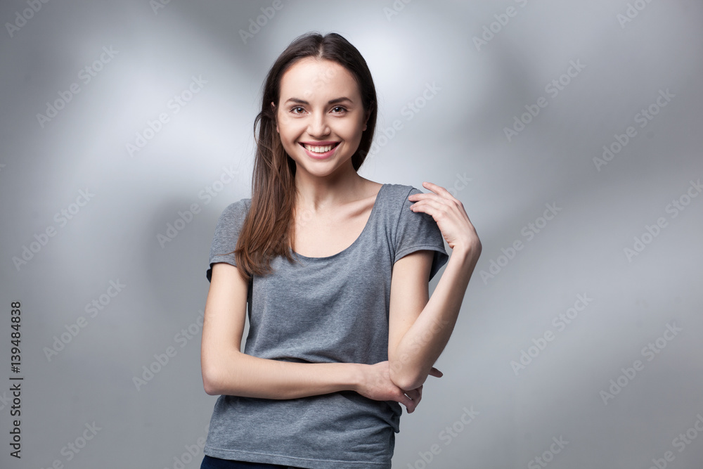 closeup studio portrait of young woman in grey shirt over light studio backgtound closeup studio portrait of young woman in grey shirt over light studio backgtound