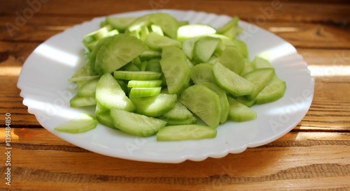 Freshly sliced cucumber slices on a white plate
