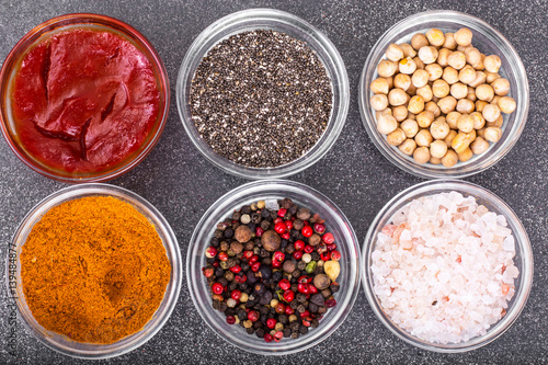 Various dry spices  sauces and cereals in glass molds on backgro