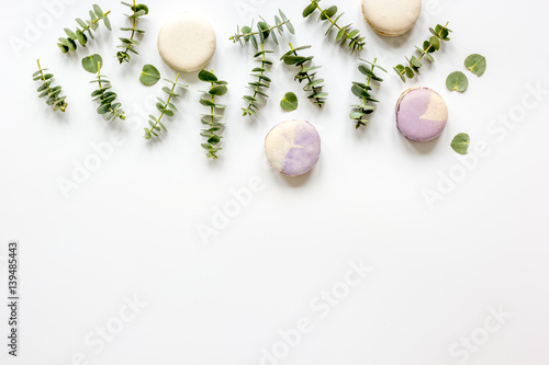 Macaroons and eucalyptus on woman table top view mock up