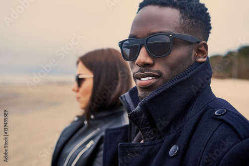Close up portrait of Black male and Caucasian female on a beach.