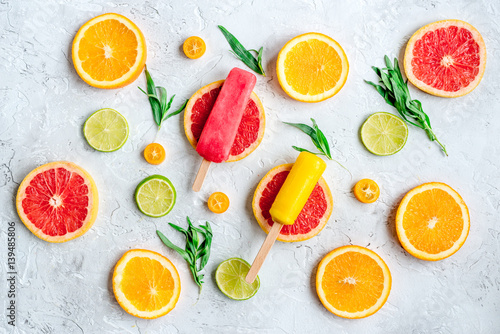 citrus popsicles with fruit slices on stone background top view pattern