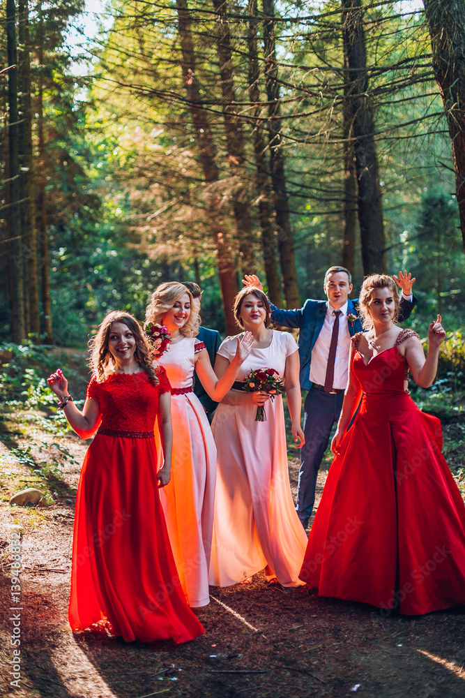 Bride and groom with happy groomsmen and bridesmaids having fun and popping champagne ilarious moment. Newlyweds fun with friends. Dancing people.