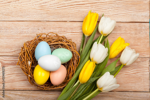 Easter Eggs in a birds nest with colorful tulips