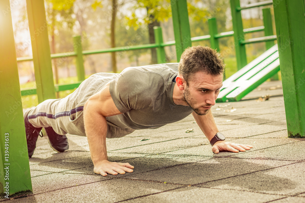 Push-ups - fitness man training push up outside in summer. Push-ups - fitness man training push up outside in summer.