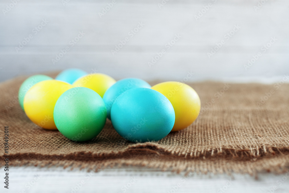 Colored eggs on sacking. The concept of a happy Easter.