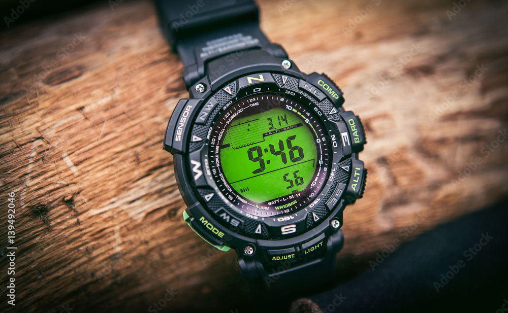 Sport watch on hand with empty screen on nature green background Sport watch on hand with empty screen on nature green background