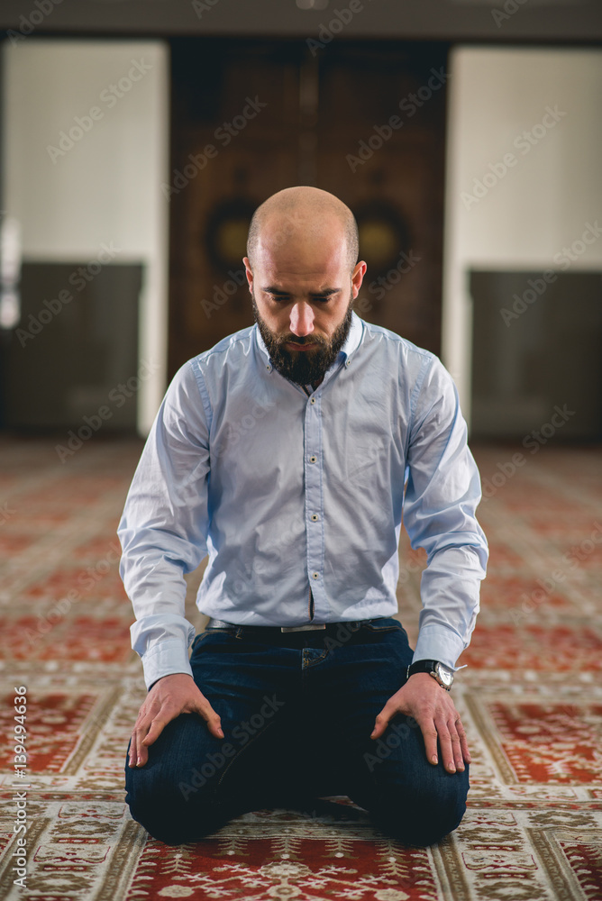 Humble Muslim man sitting and kneeling in prayer Humble Muslim man sitting and kneeling in prayer