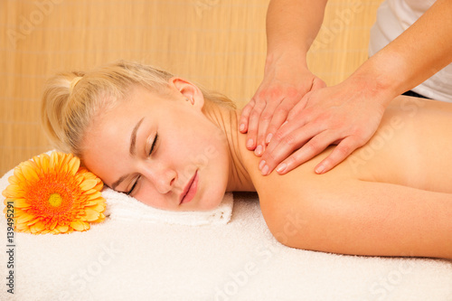 Beautiful blonde woman enyoing massage treatment in sap salon