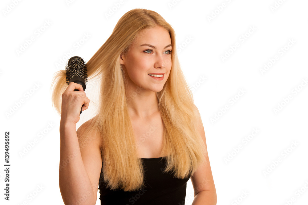 Beautiful blonde woman brushing her hair as a sign og hair care Beautiful blonde woman brushing her hair as a sign og hair care