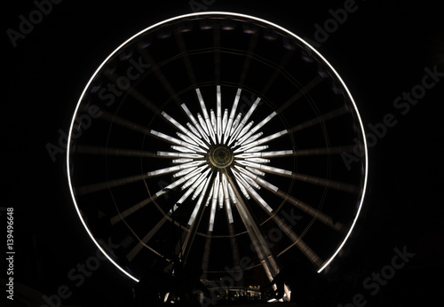 White star ferris wheel brightly lit at amusement park at night  dark background