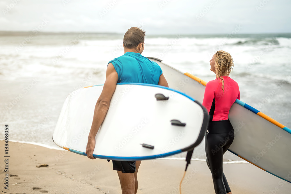 Couple of surfers on ocean's shore