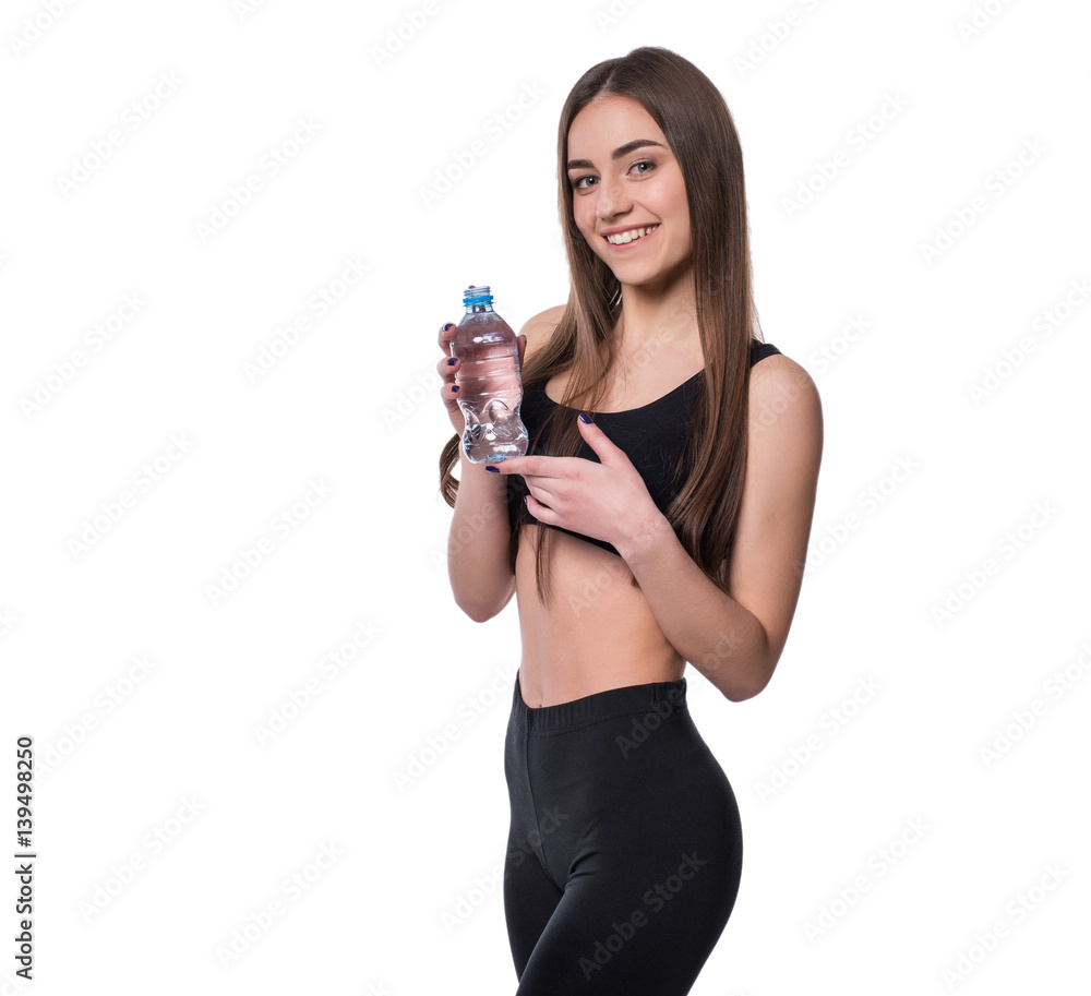 Positive female fitness model after workout holding a bottle of pure water over white background. Positive female fitness model after workout holding a bottle of pure water over white background.