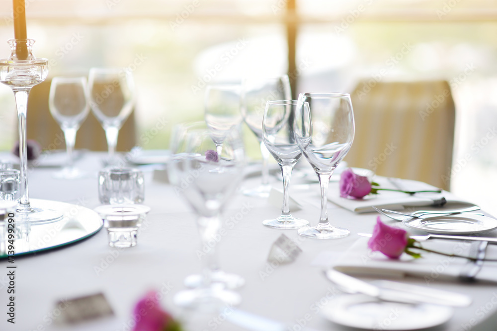 Beautiful table setting with crockery and flowers for a party, wedding reception or other festive event Beautiful table setting with crockery and flowers for a party, wedding reception or other festive event
