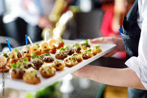 Valokuva Waiter carrying plates with meat dish on festive event, party or wedding recepti