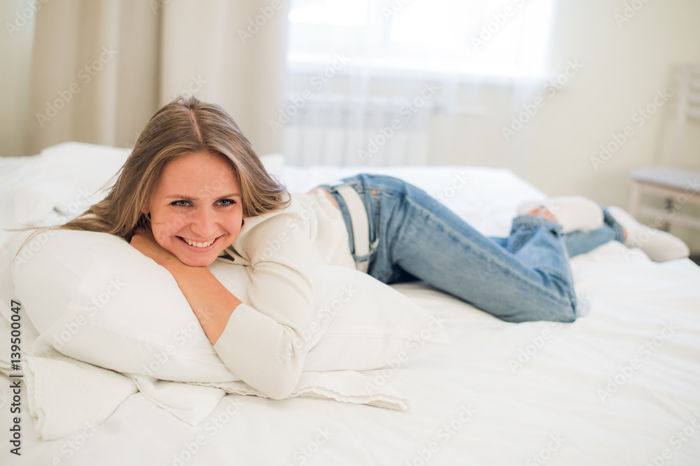 Smiling thoughtful pretty woman lying in bed at home Smiling thoughtful pretty woman lying in bed at home