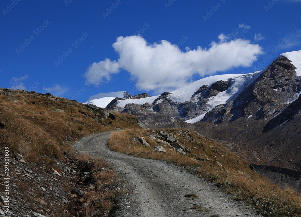 Curved gravel road in Zermatt. Findel glacier.