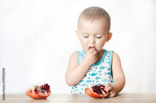 A child eating a pomegranate photo