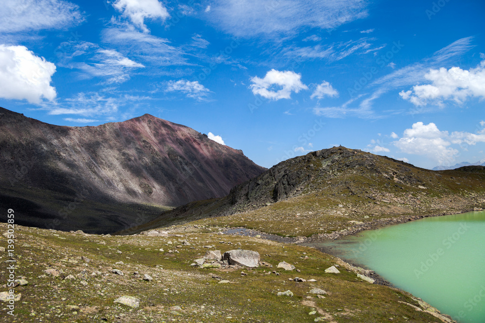 Fototapeta premium Amazing picture of green mountain landscape with blue sky and white clouds. Great nature,sunlight at the middle of summer day. Lake and color hill.
