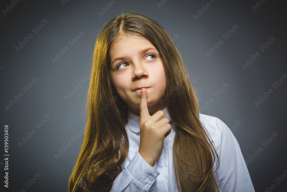 Closeup Thoughtful girl with Hand at head isolated on Gray Closeup Thoughtful girl with Hand at head isolated on Gray