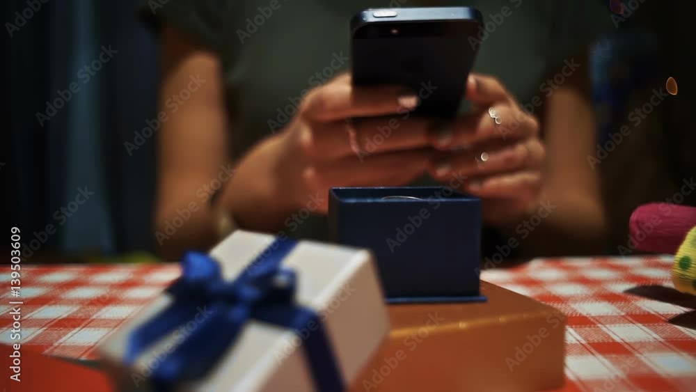 Close up female taking a photo on smartphone of a small blue secret present box hd Close up female taking a photo on smartphone of a small blue secret present box hd