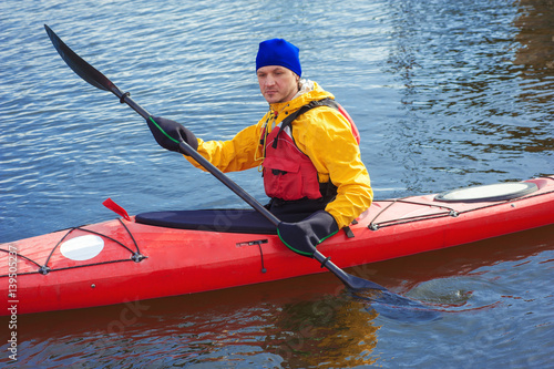 man kayaking on a red kayak on excursions in nature 07 © serguastock
