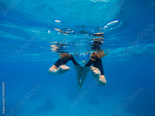 Woman swimming in blue water. Beautiful woman under water before dive to coral reef.