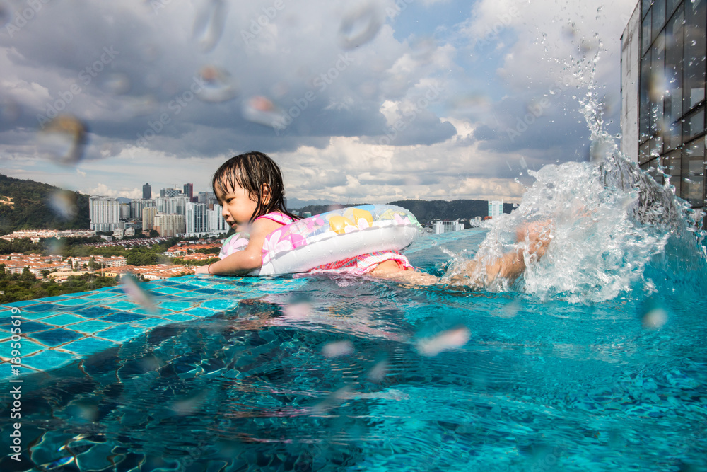 Asian Chinese little girl learning at the outdoor swimming pool