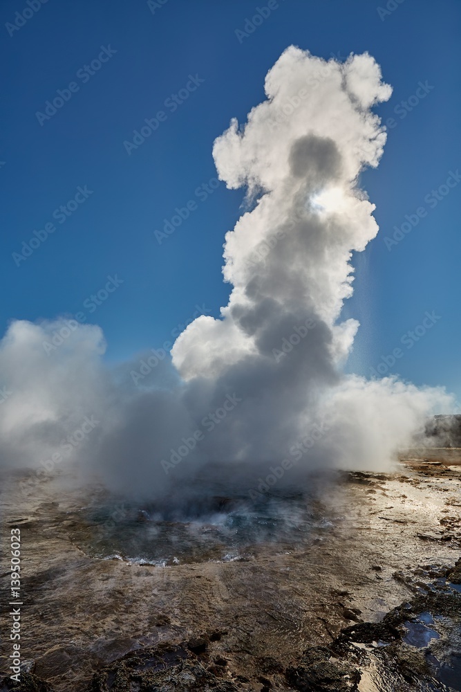 Erupting geyser in sunlight