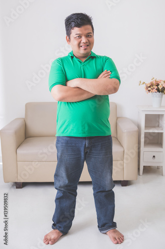 asian male smiling to camera with armcrossed © Odua Images