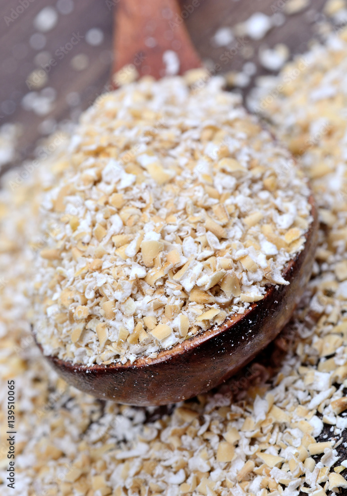 Oat in a spoon on wooden background Oat in a spoon on wooden background
