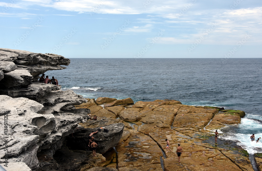 Sydney, Australia - Feb 5, 2017. People relaxing on the rocks of Ray O'Keefe Reserve, North Bondi.